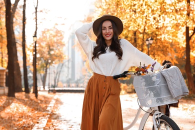 Beautiful happy woman with bicycle in autumn park