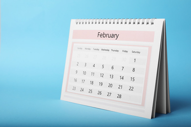 Photo of Paper calendar on light blue background. Planning concept