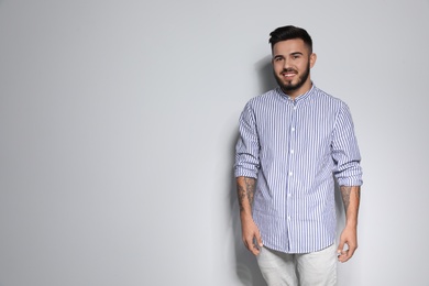 Portrait of handsome young man against light background. Space for text