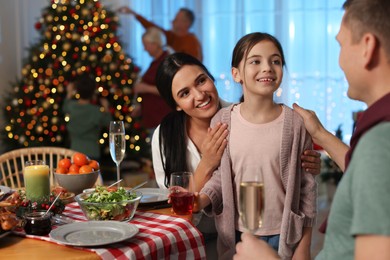 Happy family celebrating Christmas at home in evening