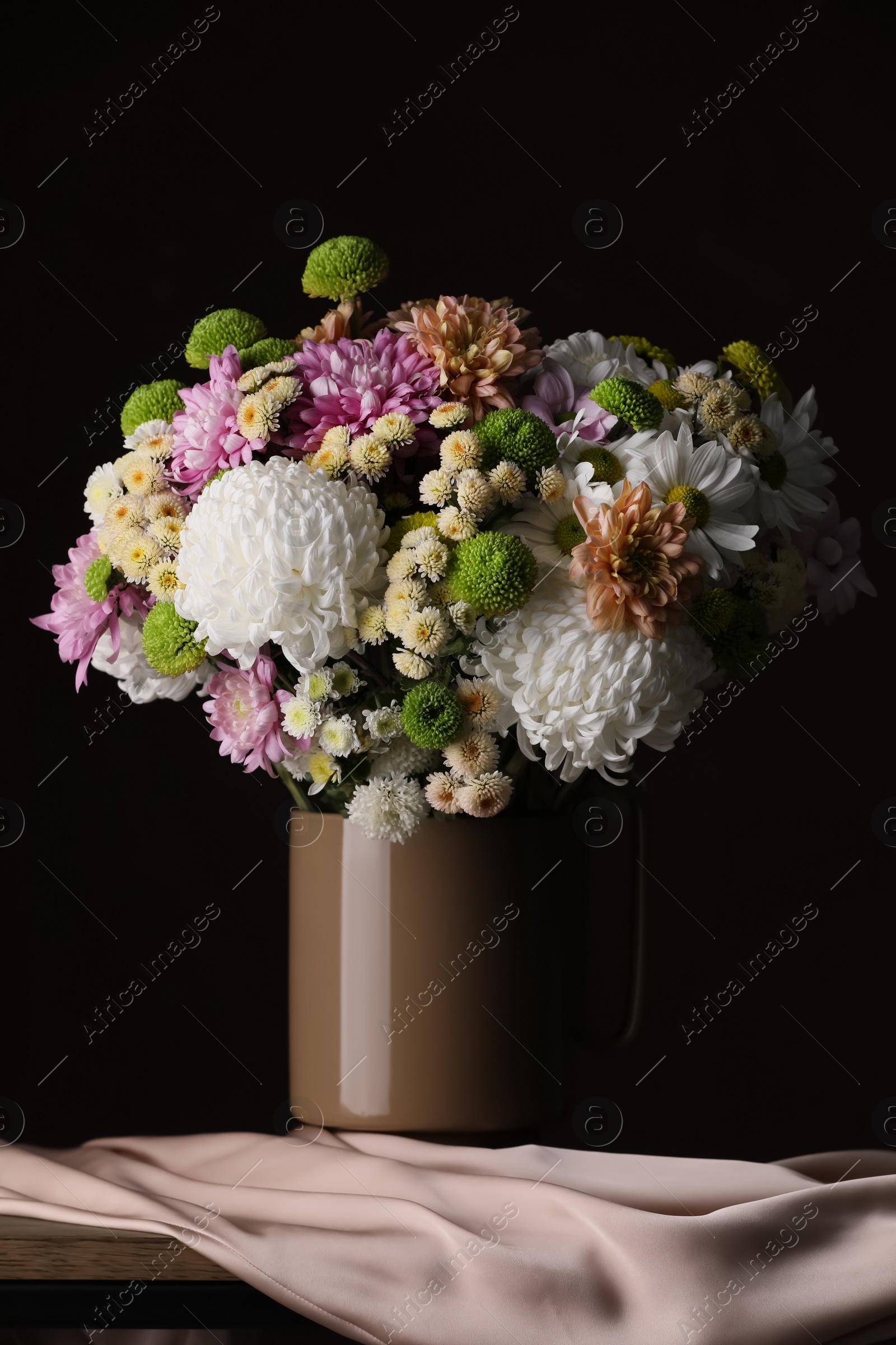 Photo of Bouquet of beautiful chrysanthemum flowers on table against dark background