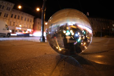 Crystal ball on asphalt road at night. Wide-angle lens
