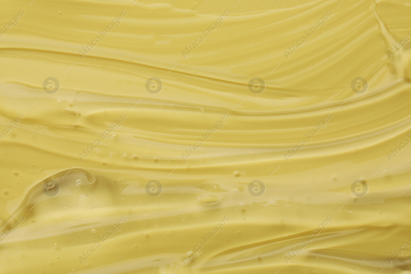 Photo of Clear cosmetic gel on yellow background, closeup