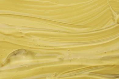 Clear cosmetic gel on yellow background, closeup