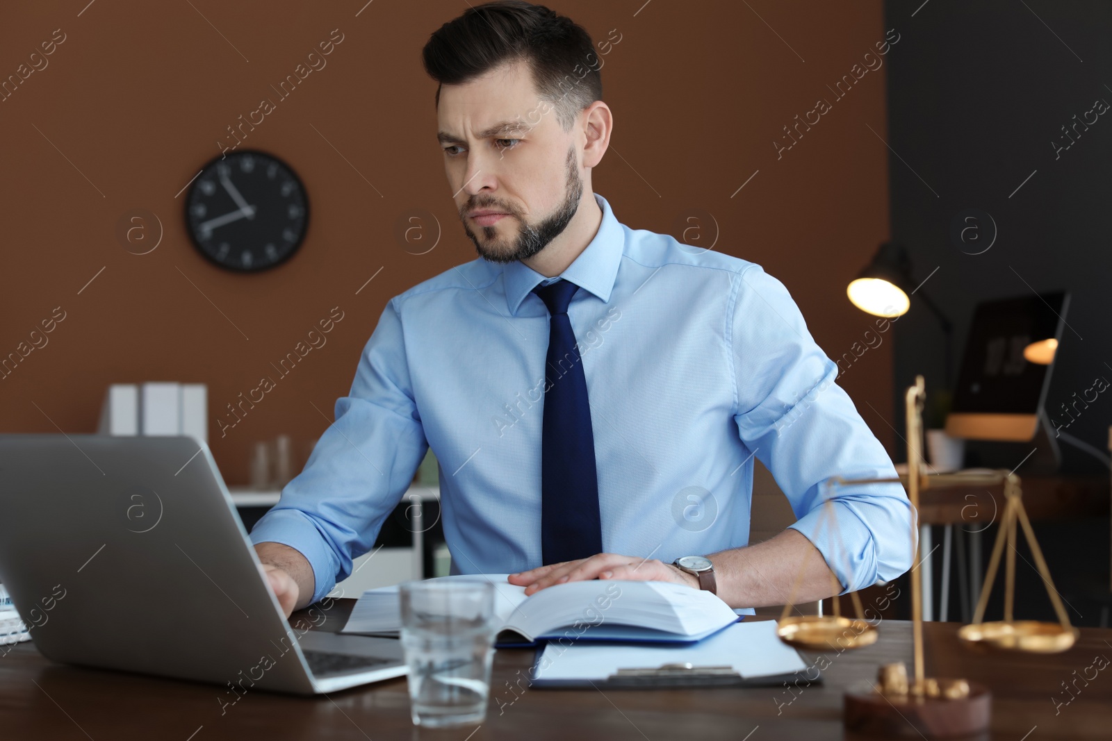 Photo of Male lawyer working with laptop in office