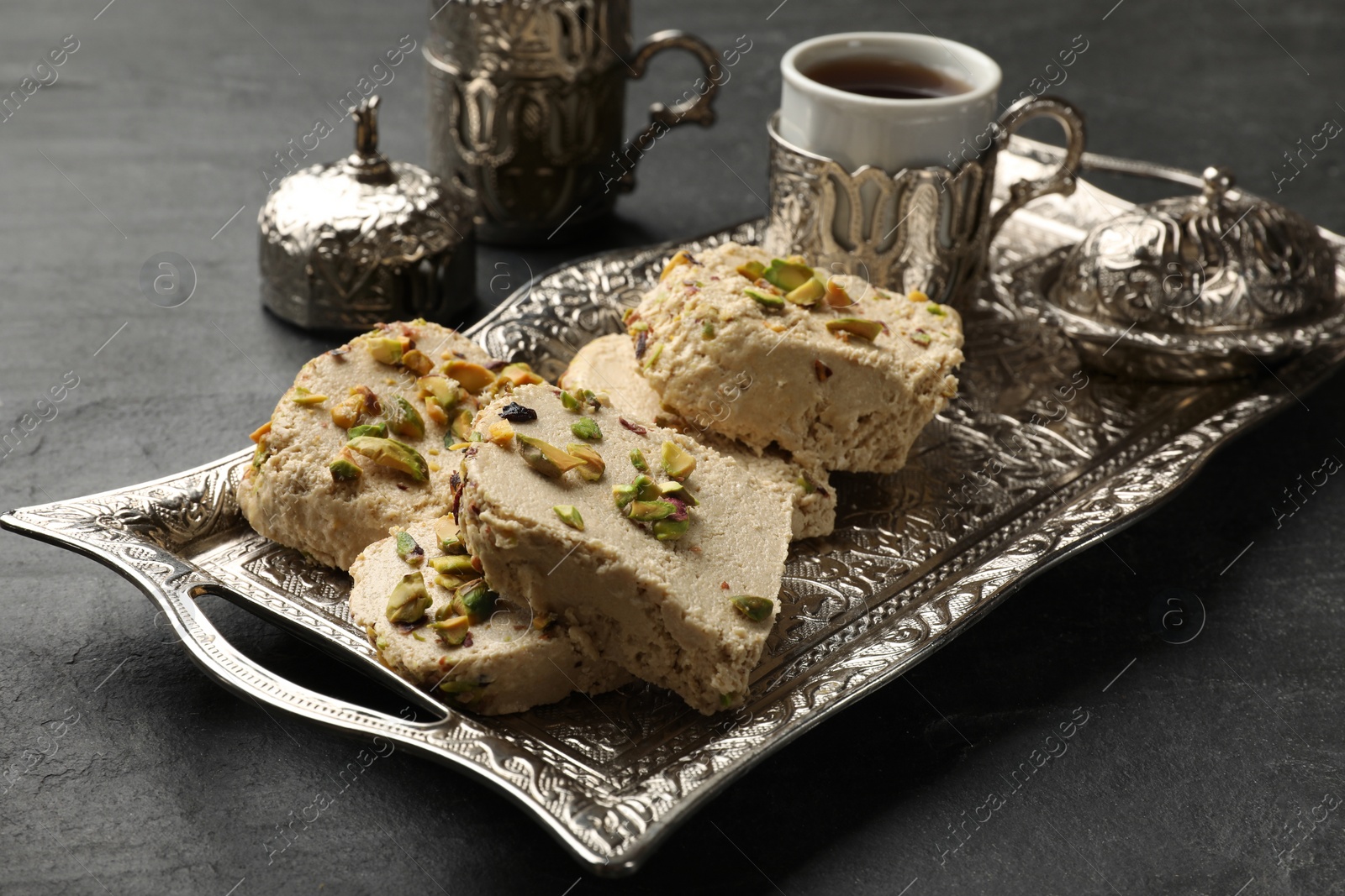 Photo of Tasty pistachio halva served on grey table