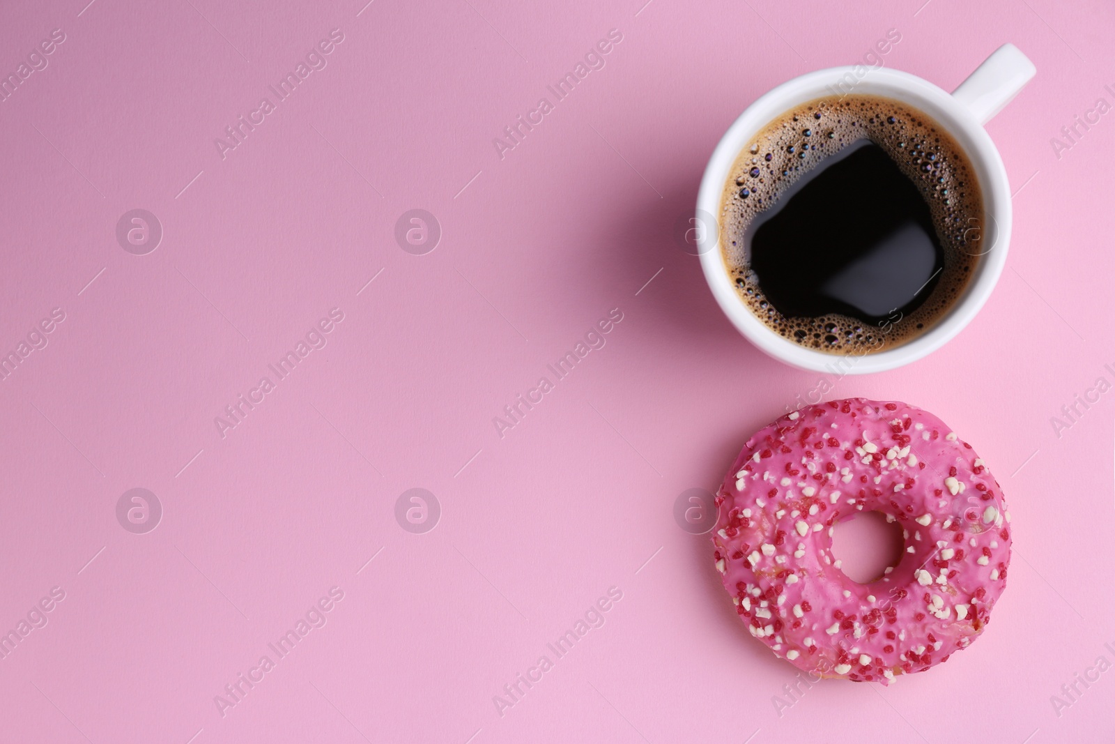 Photo of Tasty donut and cup of coffee on pink background, flat lay. Space for text