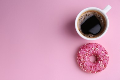 Photo of Tasty donut and cup of coffee on pink background, flat lay. Space for text