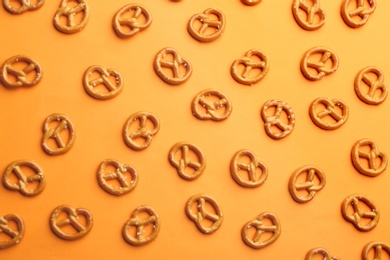 Photo of Delicious pretzel crackers on orange background, flat lay