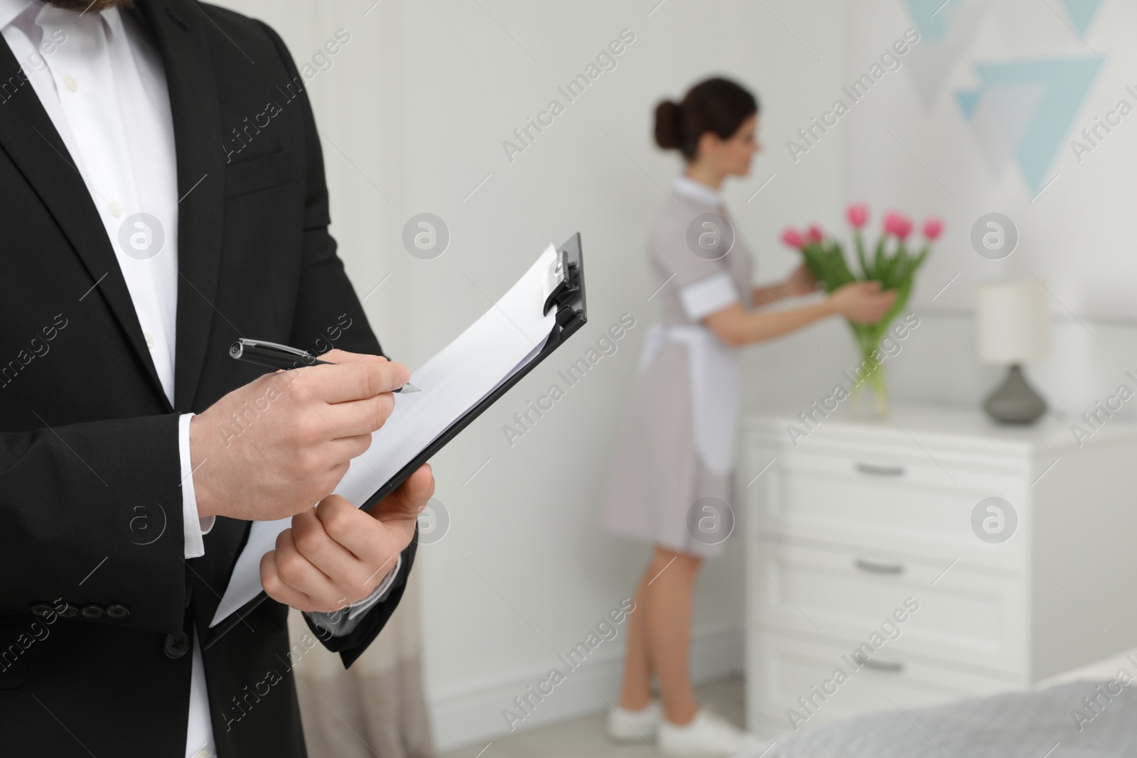 Photo of Housekeeping manager checking maid work in hotel room, closeup
