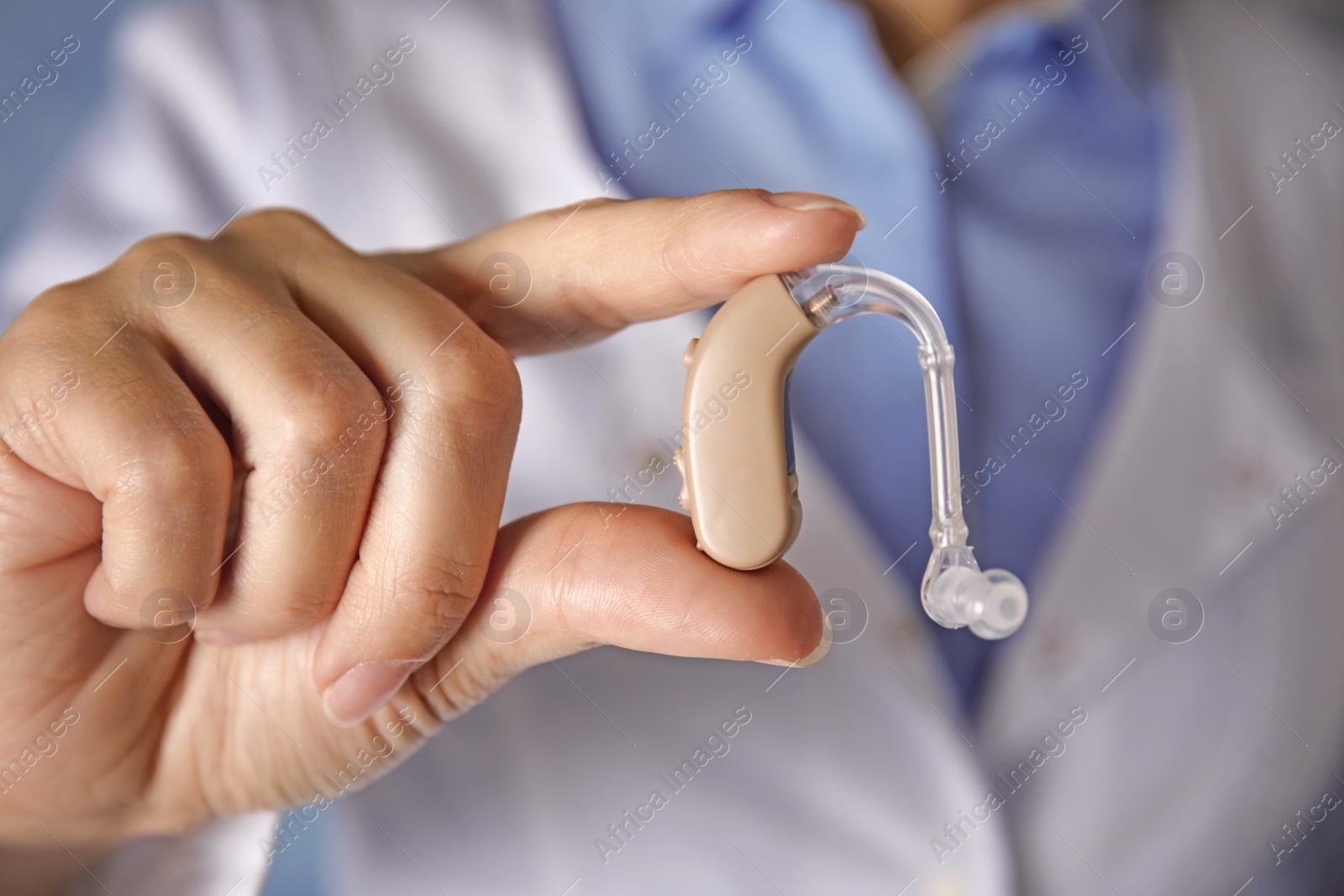 Photo of Doctor in white coat with hearing aid, closeup