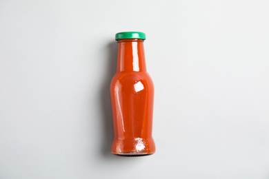 Photo of One bottle with tasty drink on color background, top view