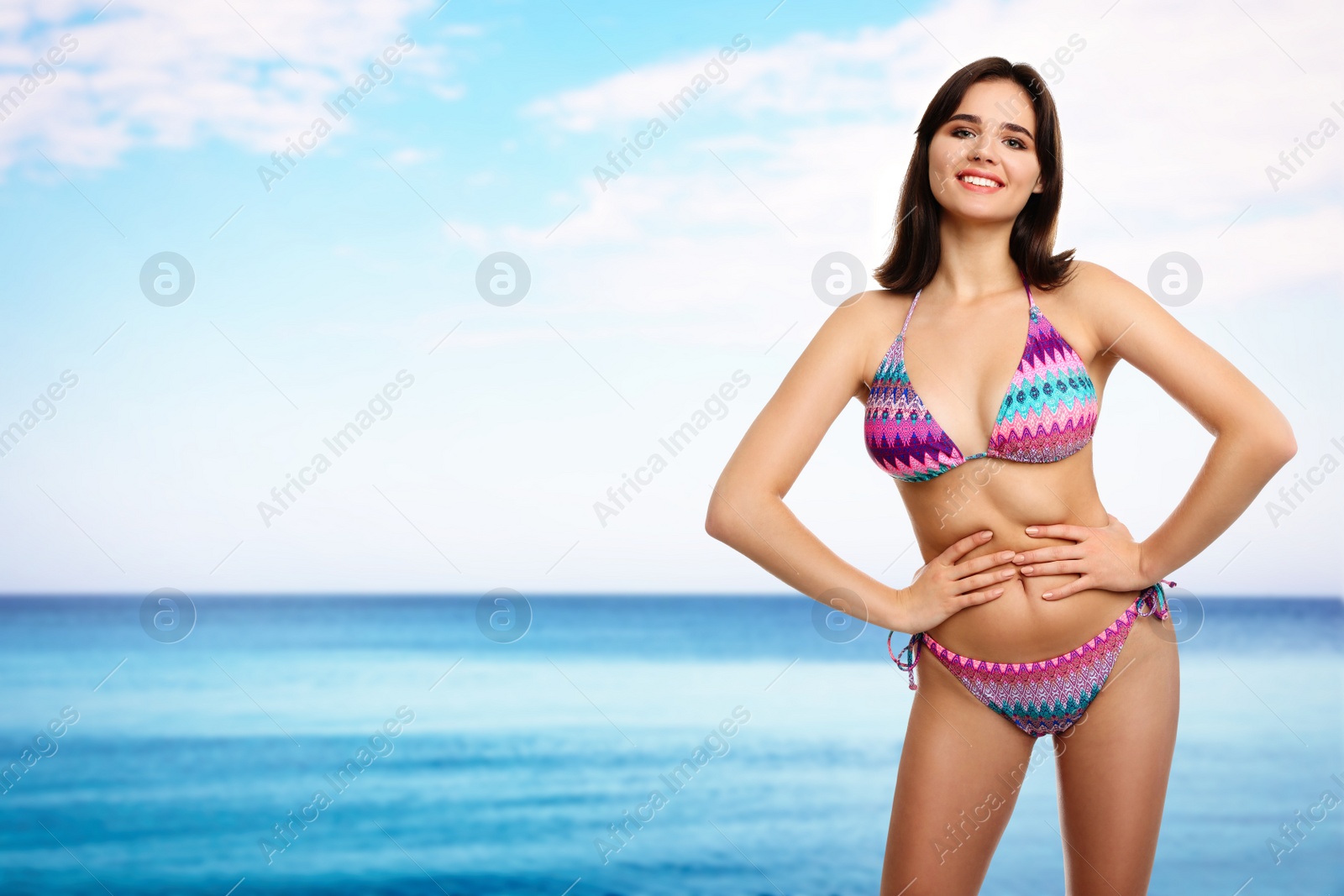 Image of Beautiful woman in stylish bikini near sea on sunny day, space for text