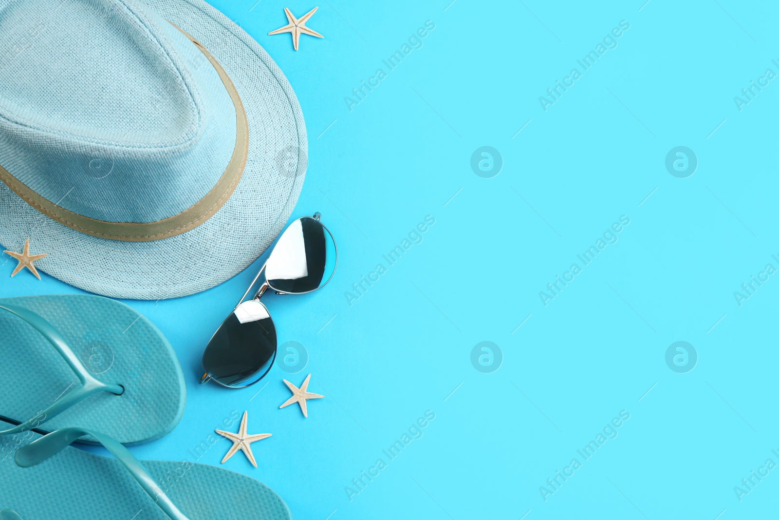 Photo of Flat lay composition with sunglasses and beach accessories on blue background. Space for text