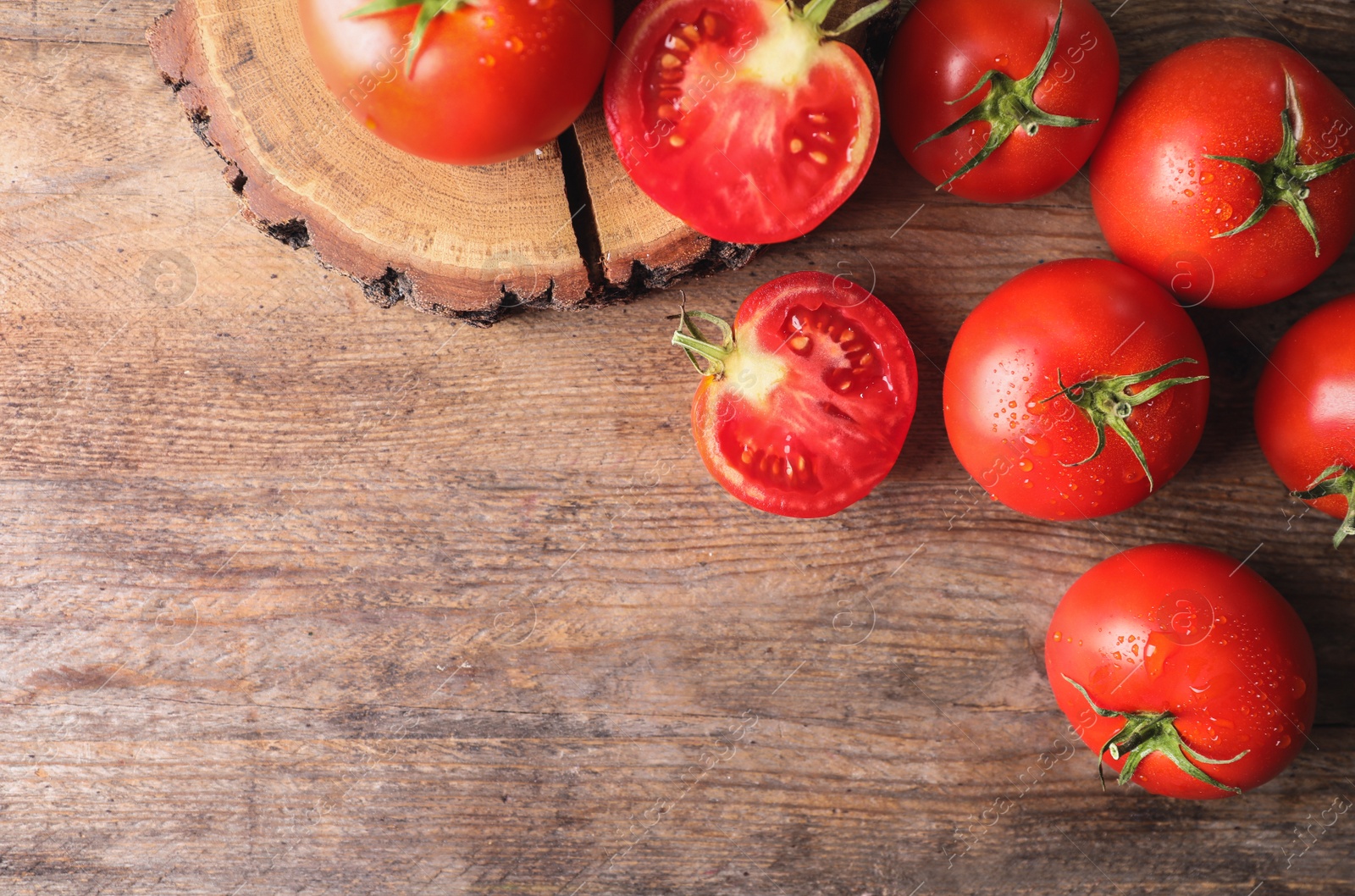 Photo of Fresh ripe tomatoes on wooden table, flat lay. Space for text