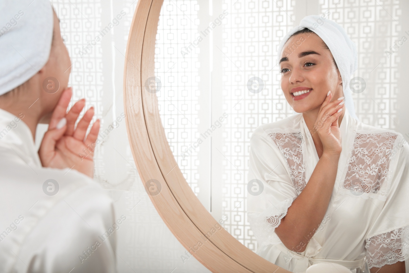 Photo of Beautiful young woman with perfect skin near mirror in bathroom. Facial wash