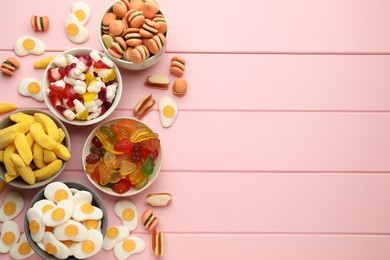 Photo of Many different delicious gummy candies on pink wooden table, flat lay. Space for text