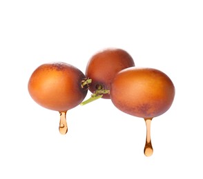 Oil dripping from palm fruits on white background