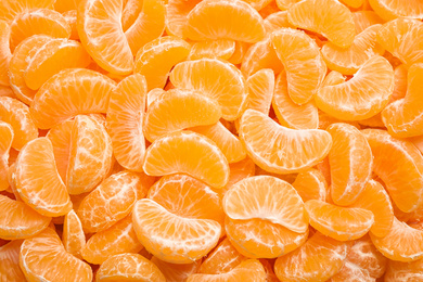 Fresh juicy tangerine segments as background, top view