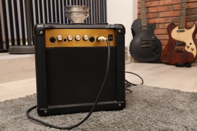 Photo of Modern guitar amplifier on floor in studio