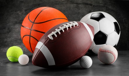 Photo of Many different sports balls on dark gray background