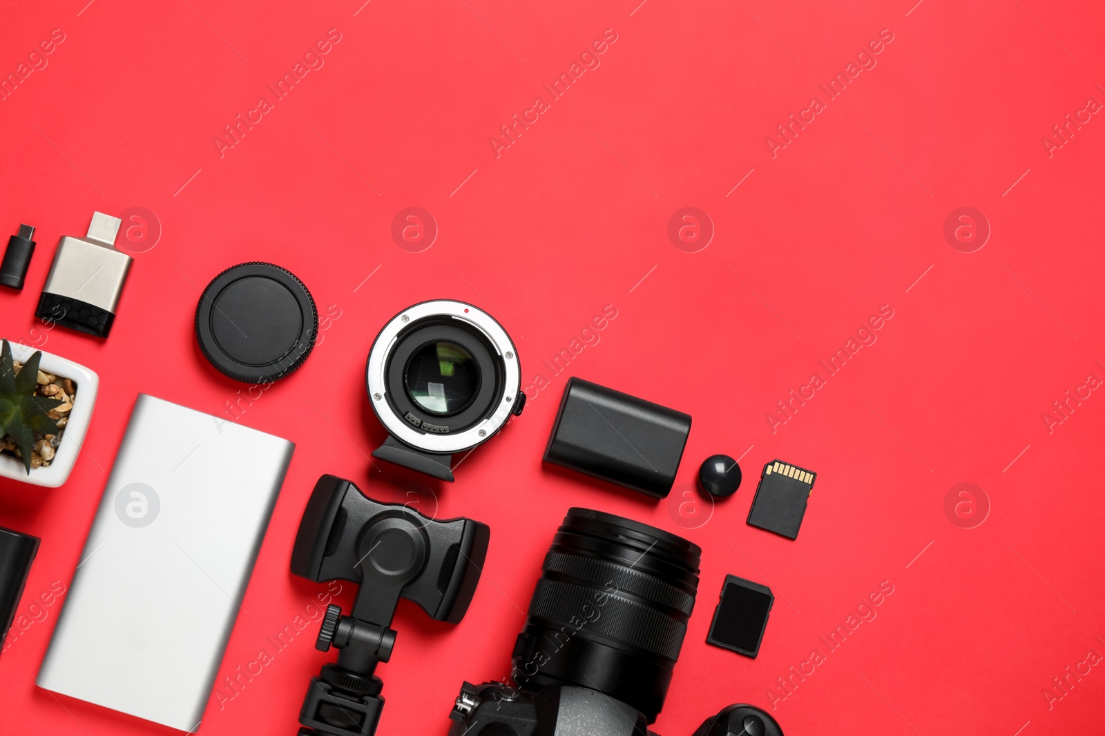 Photo of Flat lay composition with camera and video production equipment on red background. Space for text