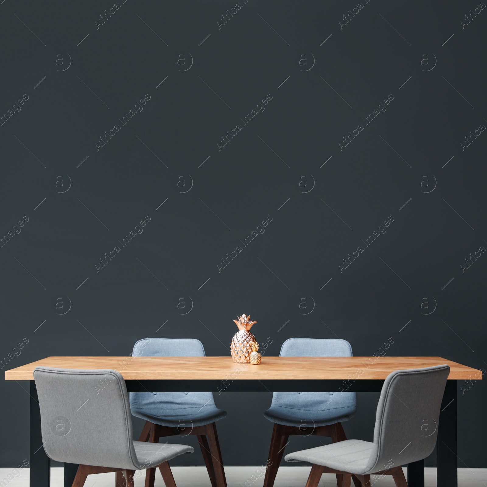 Photo of Modern table with decorative pineapples near black wall