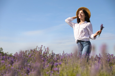 Young woman with lavender bouquet in field on summer day