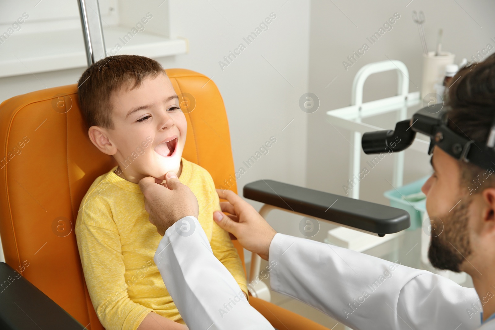 Photo of Professional otolaryngologist examining little boy in clinic