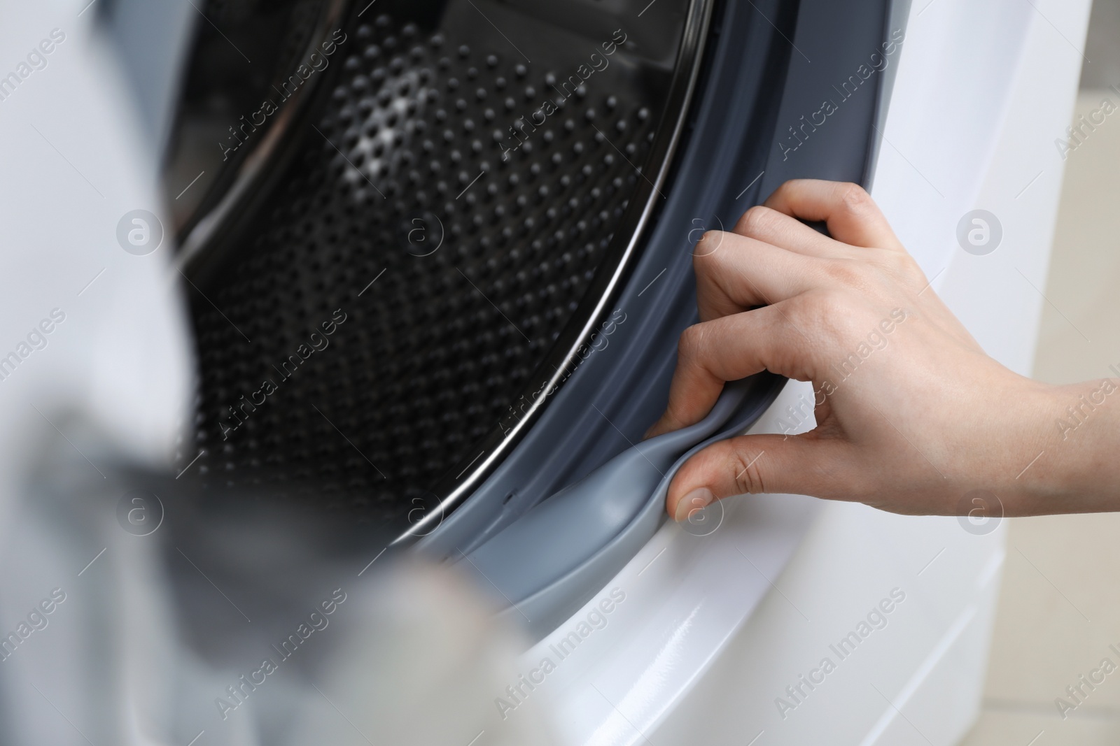 Photo of Woman cleaning empty washing machine, closeup view