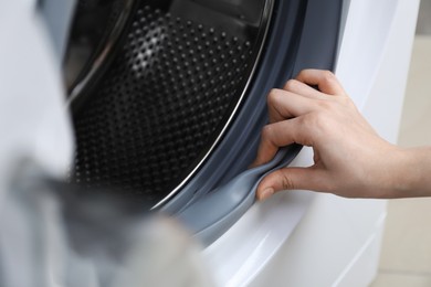 Photo of Woman cleaning empty washing machine, closeup view