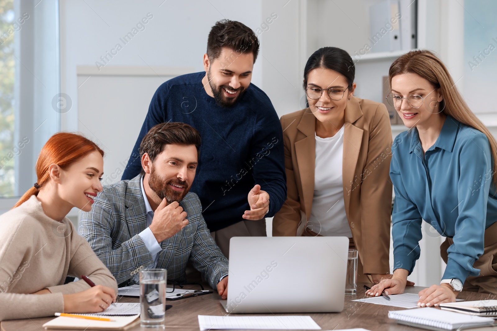 Photo of Team of employees working together in office