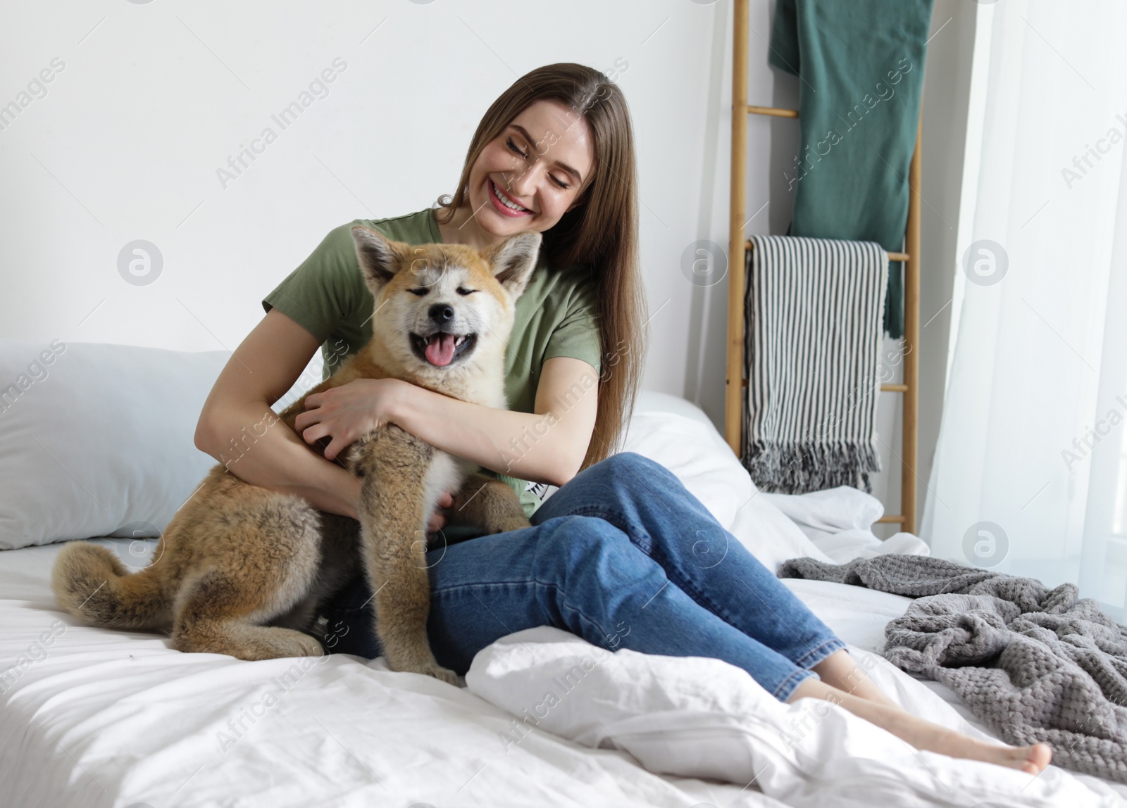 Image of Happy woman with her cute Akita Inu puppy at home