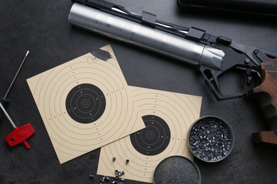 Photo of Flat lay composition with sport pistol on black table. Professional gun