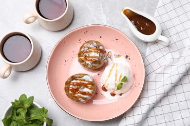 Photo of Delicious baked apples with nuts, ice cream and caramel served on white table, flat lay