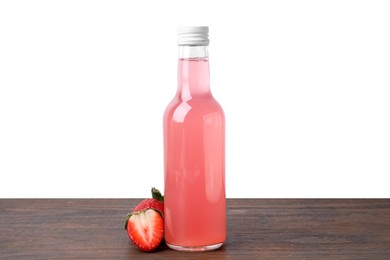 Photo of Delicious kombucha in glass bottle and strawberries on wooden table against white background