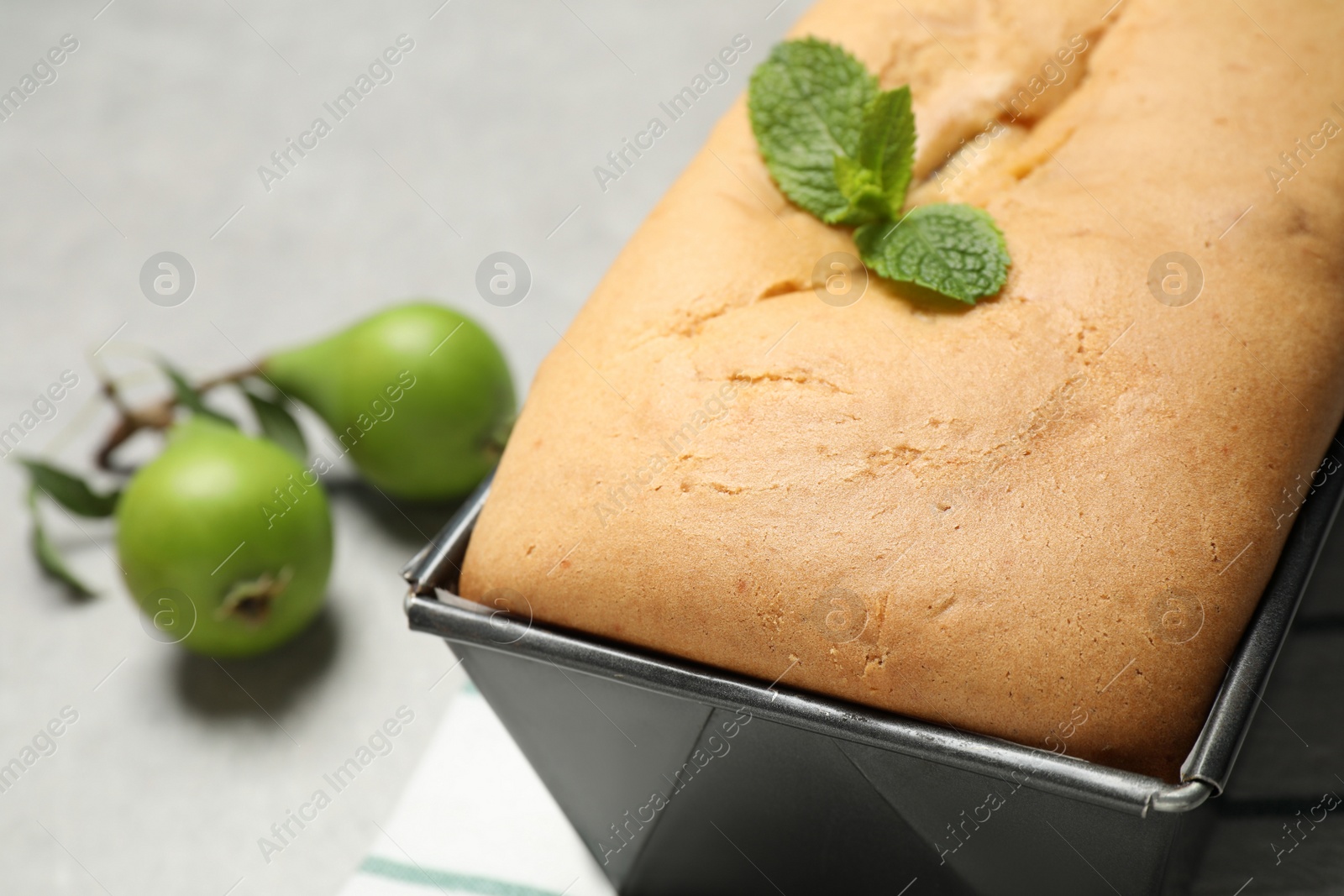 Photo of Tasty bread with mint and pears on light grey table, closeup. Homemade cake