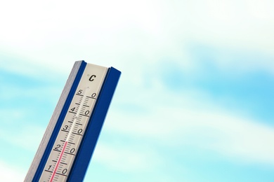 Photo of Weather thermometer and blue cloudy sky on background. Space for text