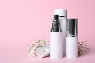 Photo of Set of luxury cosmetic products and flowers on pink background. Space for text