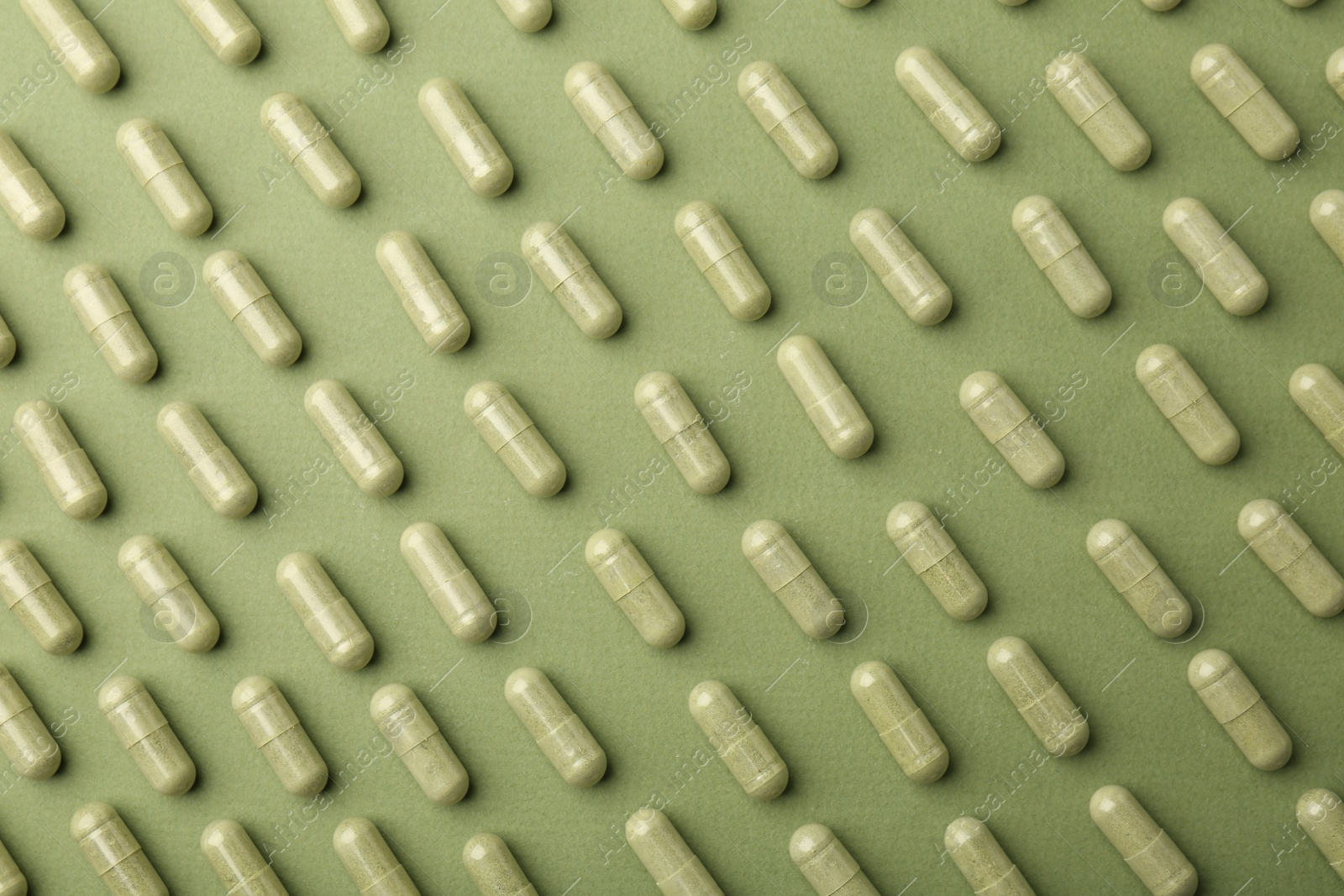 Photo of Vitamin capsules on olive background, flat lay