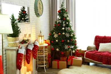 Stylish interior with beautiful Christmas tree and decorative fireplace