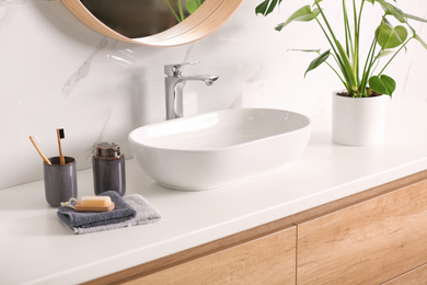 Stylish vessel sink on light countertop in modern bathroom