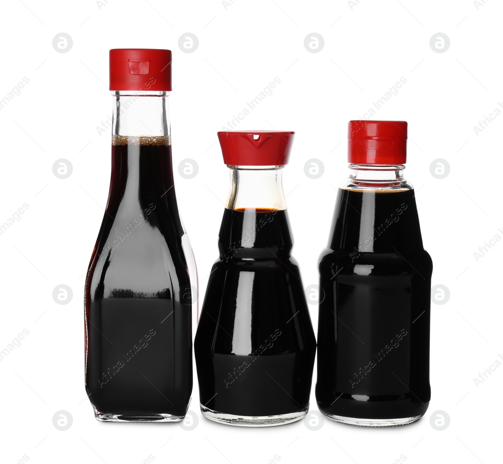 Photo of Bottles of tasty soy sauce isolated on white