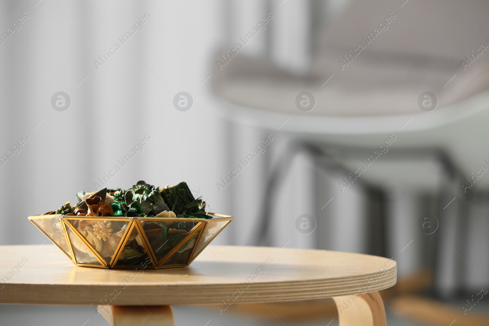 Photo of Decorative bowl with aromatic potpourri on wooden table in room, space for text