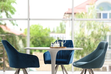 Photo of Stylish room interior with round table and comfortable chairs