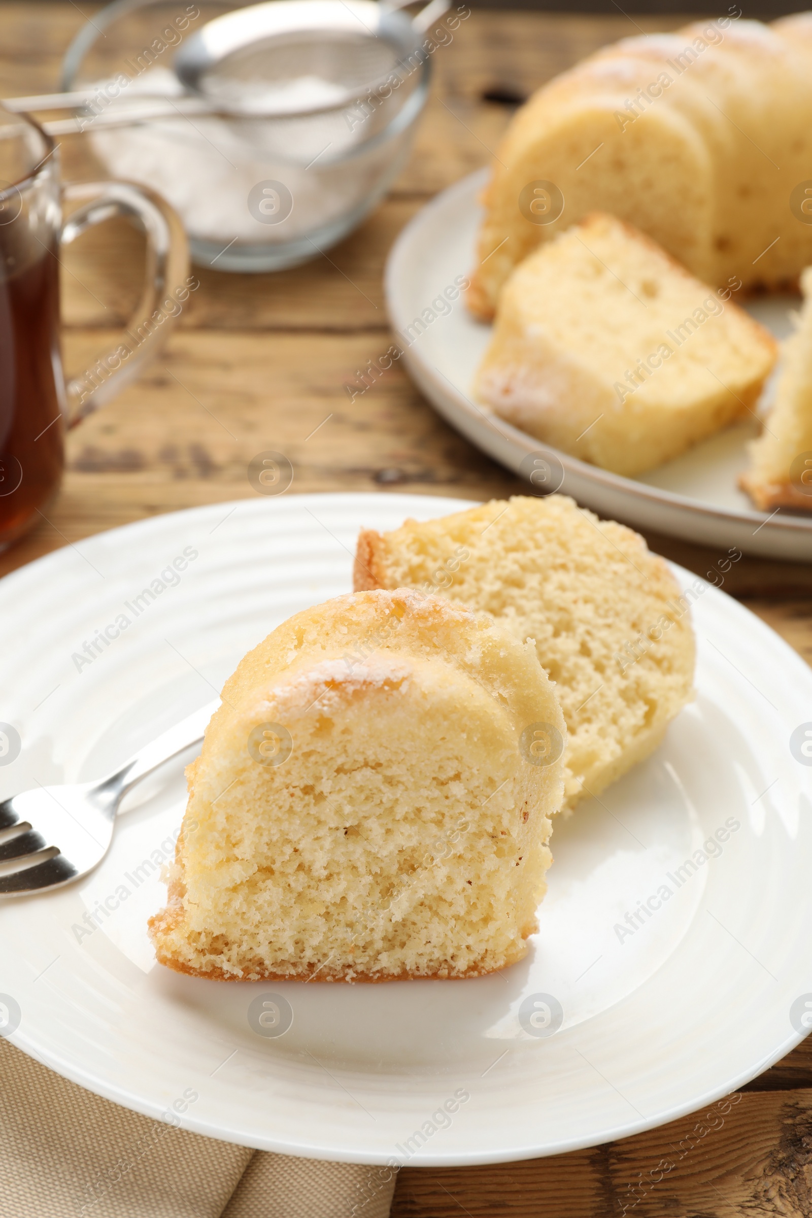 Photo of Pieces of delicious sponge cake on wooden table, closeup