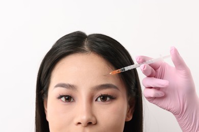 Woman getting facial injection on white background, closeup