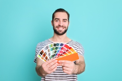 Photo of Young man with palette on color background