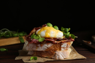 Photo of Delicious egg Benedict served on wooden table