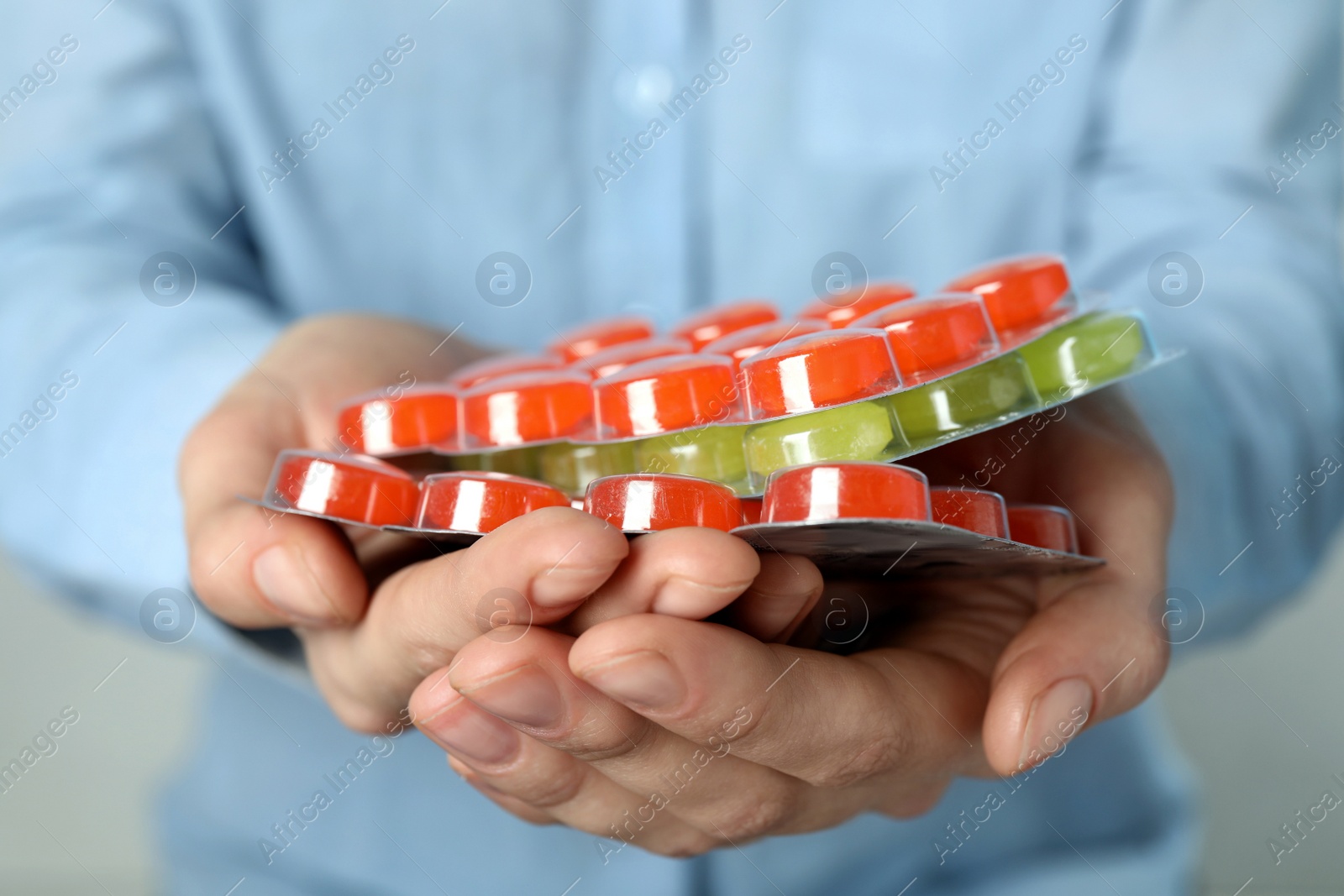 Photo of Woman holding blisters with cough drops, closeup